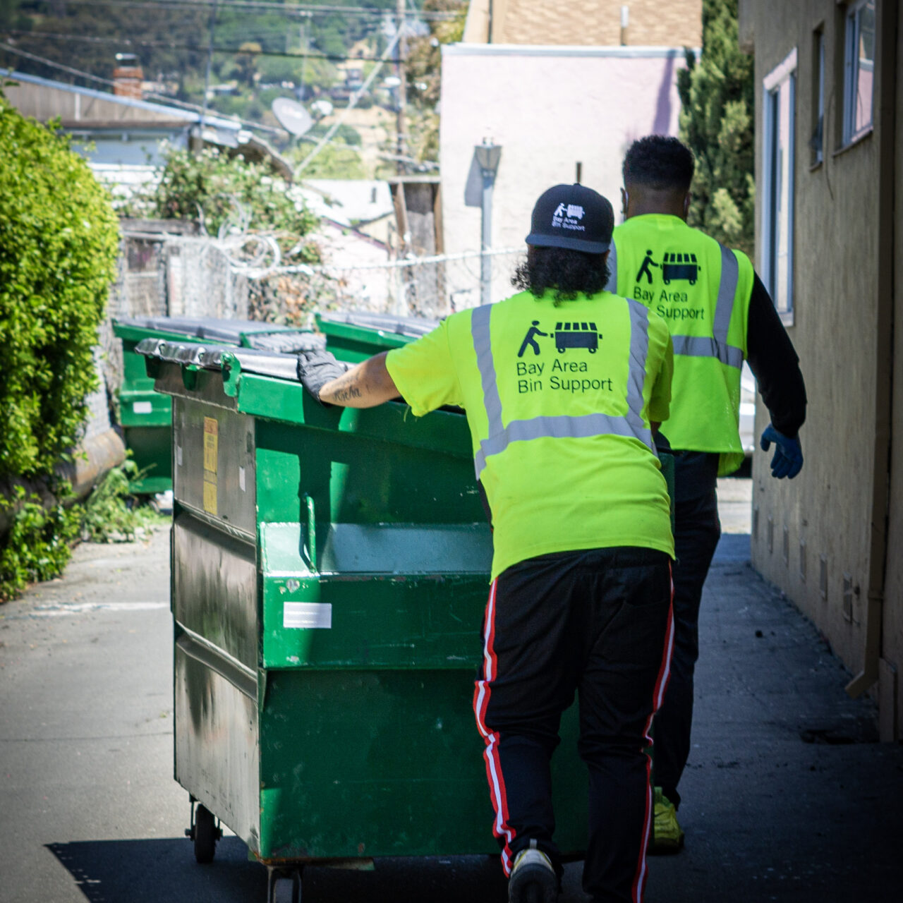 Two team members from Bay Area Bin Support pulling bins to the curb